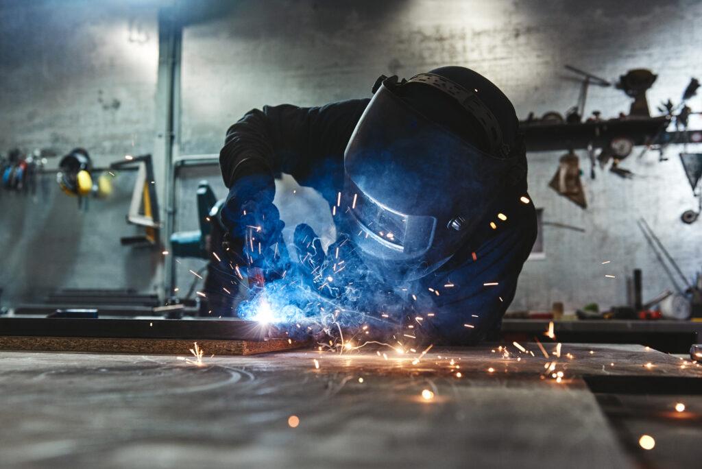 coded welder using equipment to weld steel together