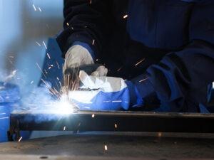 A steel fabricator working on a piece of metal.