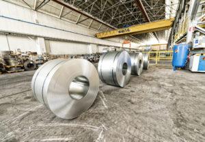 Cold rolled steel coils in storage area ready to feed to machine in metalwork manufacturing.