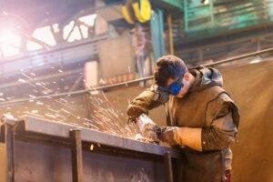 man welding steel beam in protective clothing