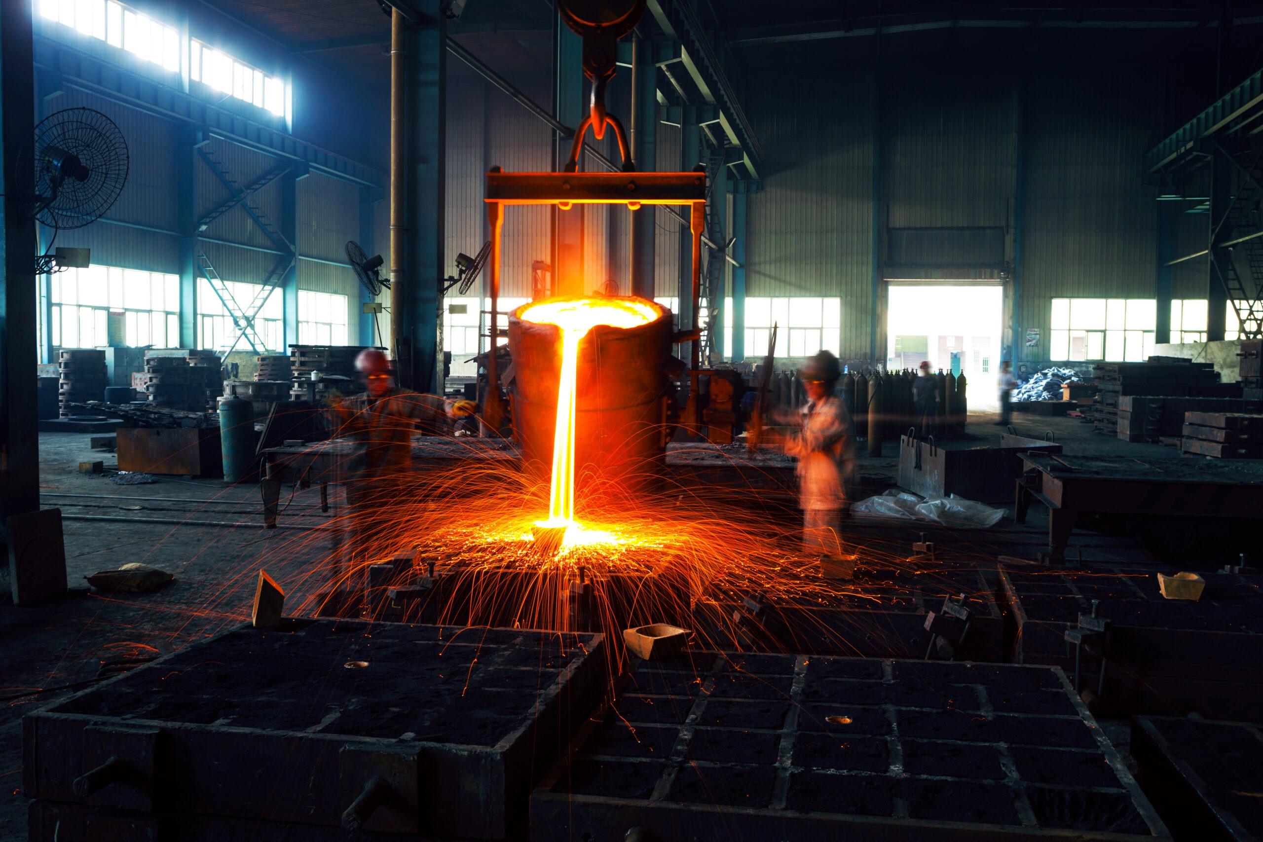 A man is pouring hot metal into a kiln.
