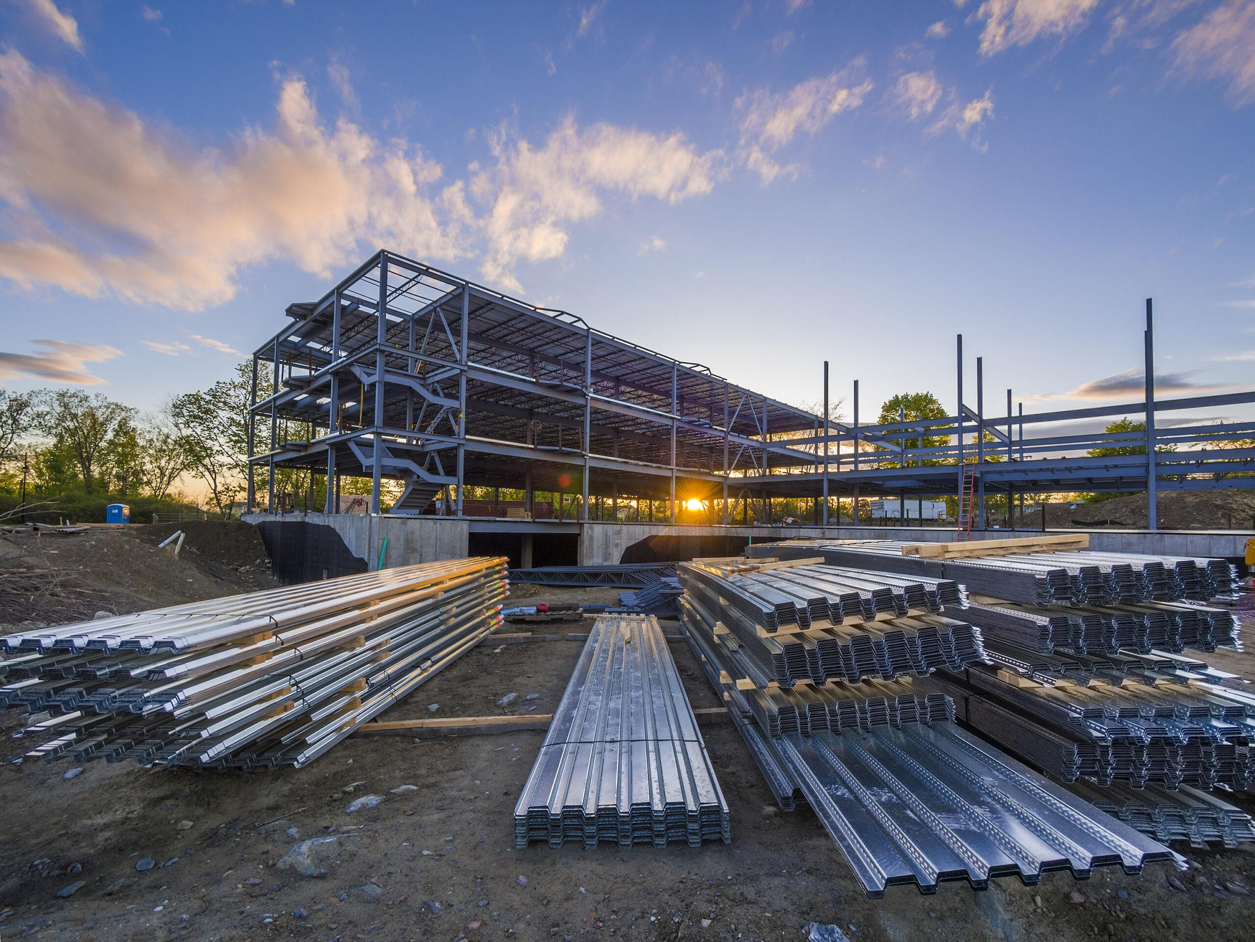 A steel structure under construction at sunset.