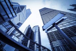A skyline featuring tall, modern steel buildings against a blue sky.