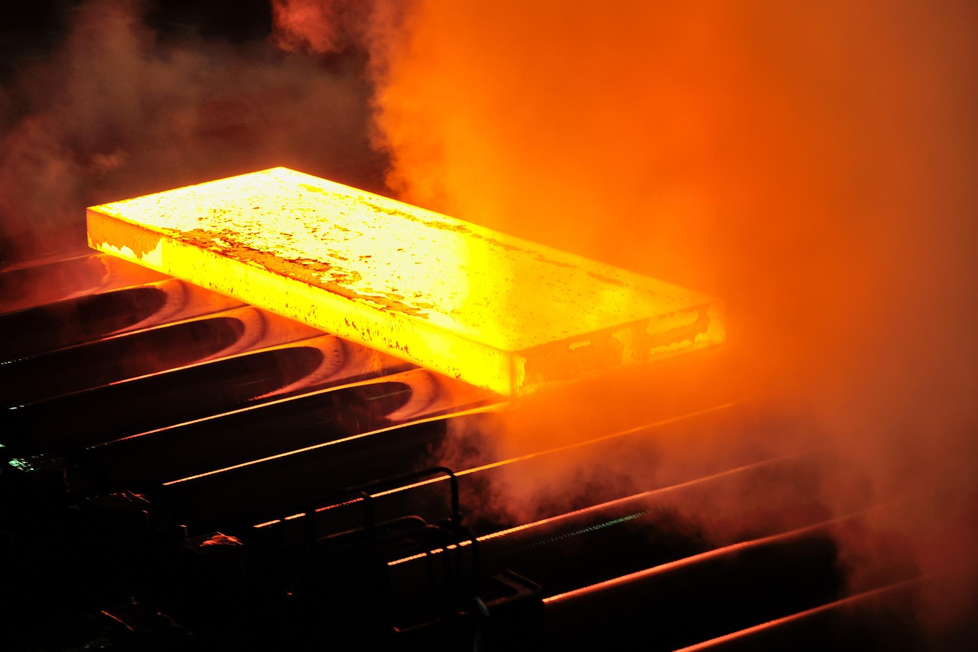 Hot steel slab moving through a steel mill production line