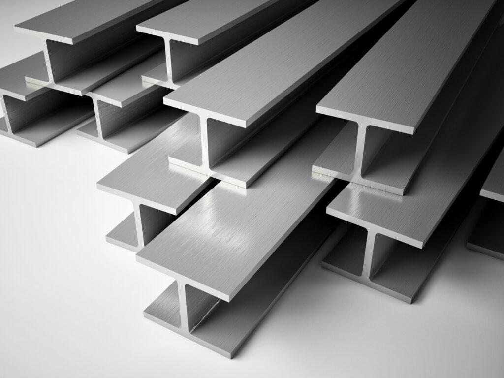 Stack of gray steel I-beams arranged in a staggered formation on a plain background.